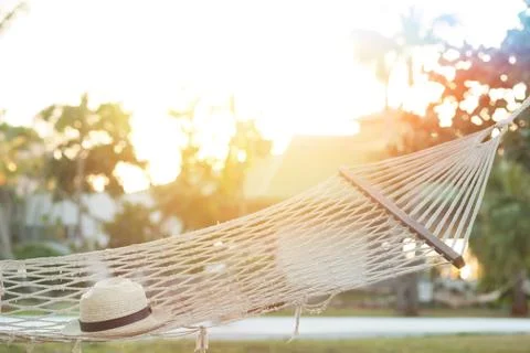 Hammock with straw hat  at sunset Stock Photos