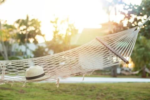 Hammock with straw hat  at sunset Stock Photos