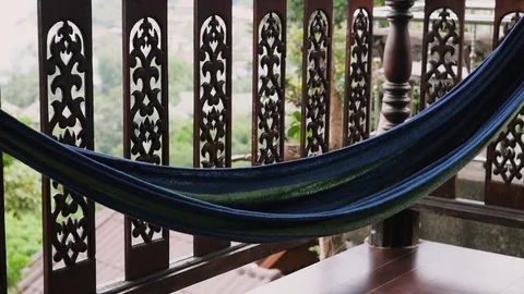 Hammock on the veranda overlooking the greenery with a multi-colored hammock Stock Footage 125992823