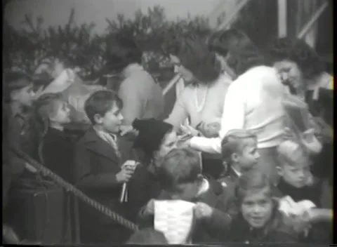 HANAU, GERMANY - 1947: Gift pickup - Families carry gifts near an open doorway Stock Footage 344488341