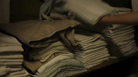 A hand accommodates clothing and bedding in a closet Vídeo Stock 46299395