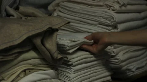 A hand accommodates clothing and bedding in a closet Stock Footage 46299655