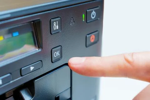 Hand Activates OK Button on Printer in Close-Up Stockfoto's