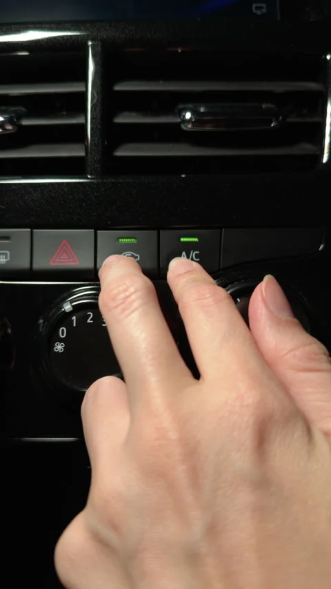 Hand activating A/C and air recirculation in the car dashboard Stock Footage 312472876