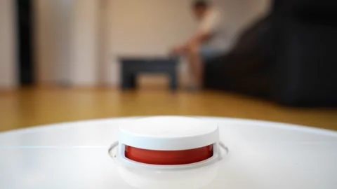 Hand Activating Smart Robotic Vacuum Cleaner in Modern Home Interior Stock Footage 321946361