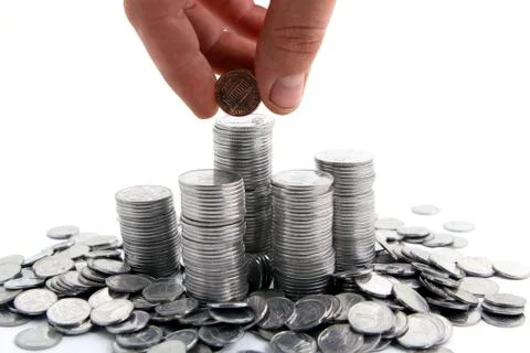 Hand adding coins Stock Photos