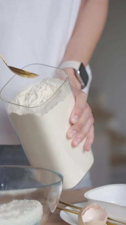 Hand adding flour to cottage cheese mixture in bowl during breakfast preparation Stock Footage 343892380