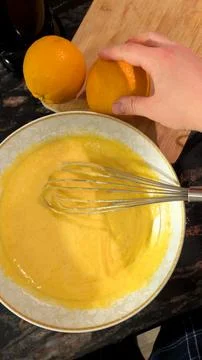 Hand Adding Fresh Oranges To Mixing Bowl For Homemade Citrus Cake Stock-Fotos