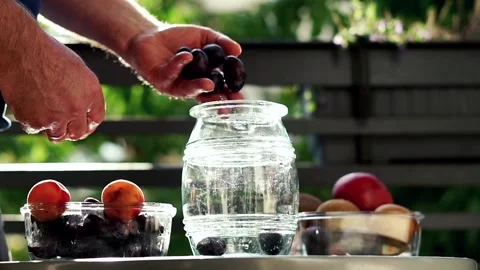 Hand adding fruits to the jar, super slow motion Stock Footage 119369062