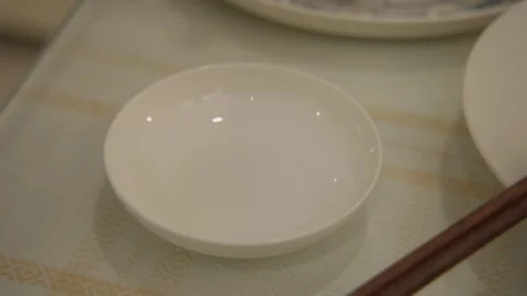 Hand Adding Garnish to Dipping Sauce in Small Bowl on Table, Beijing Food Stock Footage 345891682
