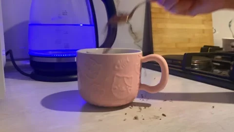 Hand adding instant coffee close-up into a ceramic mug Stock Footage 345361706