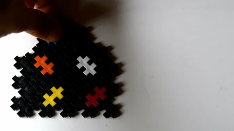 Hand adding the last piece of a house made of puzzles Stock Footage 109794525