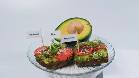 Hand adding nutrition flags to avocado bread Stock Footage 346201037
