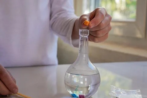 Hand Adding Orange Crystal to Glass Flask Horizontal Foto stock