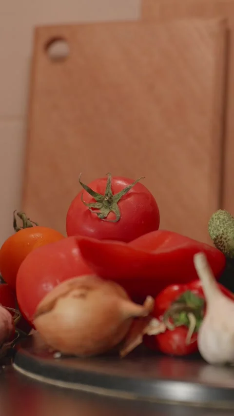 Hand adding ripe garden tomato to pile of fresh vegetables Stock Footage 340771212