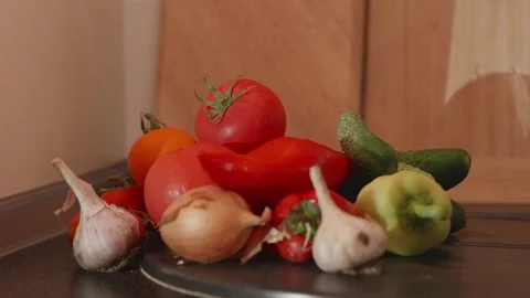 Hand adding ripe red tomato to organic vegetable pile close up Stock Footage 340771319