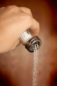 Hand adding salt Stock Photos