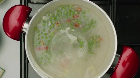 Hand Adding Stock Cube to Boiling Pea and Vegetable Soup Top View 4K Vídeos de archivo 347364442