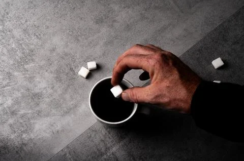 Hand Adding Sugar Cube to Coffee Stock Photos