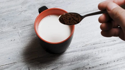 Hand adding a teaspoon of sugar to a cup of tea Video stock 121613205