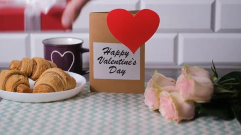 Hand adding valentines card to cozy breakfast Stock Footage 327452971