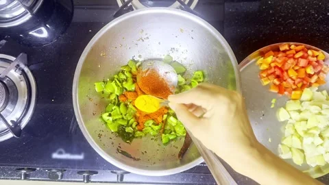 Hand adds spices into sizzling capsicum on hot pan Stock Footage 305960665