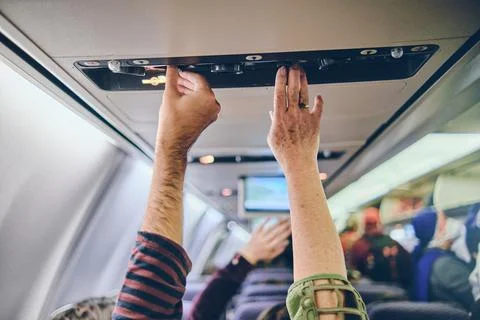 Hand up to adjust console panel aircraft, selective focus. Travel concept Stock Photos