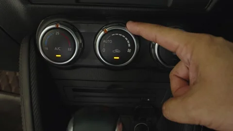 Hand adjusting the air conditioner button in the car while car moving. Stock Footage 236930102