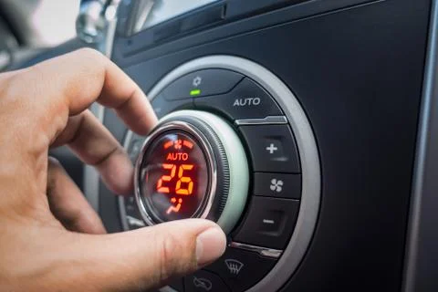 Hand adjusting air conditioner button at 26 degree in the vehicle or car for  Foto stock