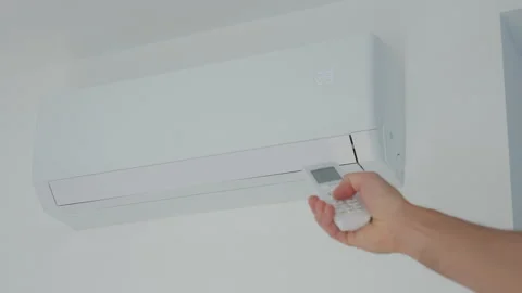 Hand adjusting air conditioner with remote control Stock Footage 336940240