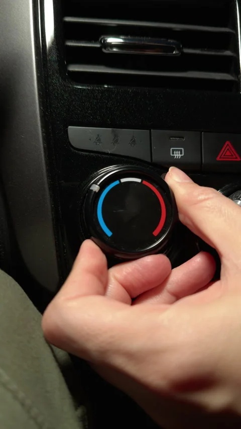 Hand adjusting car air conditioning dial during high temperature conditions Stock Footage 312470341