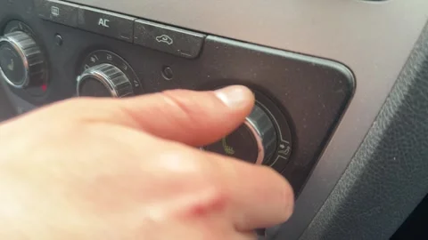 Hand adjusting car climate control knob on dashboard, vehicle heating and air Stockbeeldmateriaal 337120670