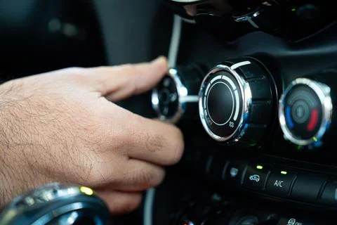 Hand Adjusting Car Climate Control Knobs Close Up in Vehicle Interior Stock Photos