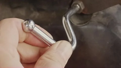 Hand adjusting chrome metal hook on motorcycle luggage hanger Stock Footage 320130335