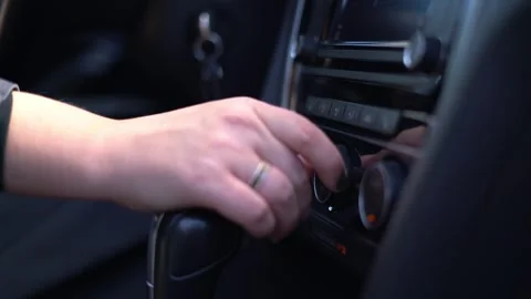 Hand adjusting climate control knob inside modern car interior Stock Footage 341809728