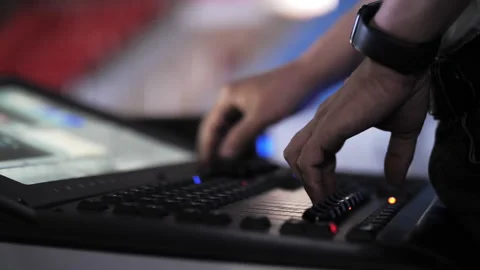 Hand adjusting controls on stage lighting console Stock Footage 307723062