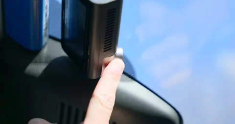 Hand adjusting dashcam on vehicle windshield for safety Video stock 336655873