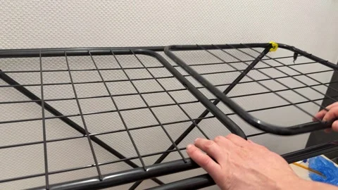 Hand adjusting a foldable clothes drying rack at home. Close up of unfolding and Stock Footage 336976577