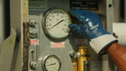 Hand adjusting fuel pump instrument dial at airport or dock 3 Stock Footage 123729699