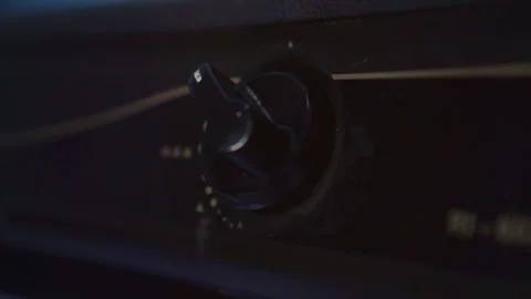 Hand adjusting a gas stove control knob, igniting the burner for cooking in a Stockbeeldmateriaal 332589000