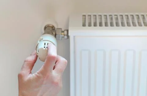 Hand adjusting heating Stock Photos