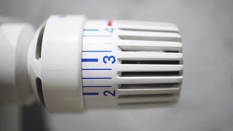 A hand adjusting the heating radiator as cold weather sets in 库存影片 295885426