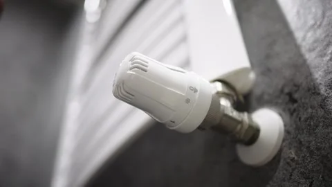 A hand adjusting the heating radiator as cold weather sets in 库存影片 295885566
