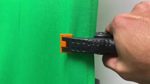 Hand adjusting locking spring clip clamp plastic holder to lock green screen 库存影片 247893651