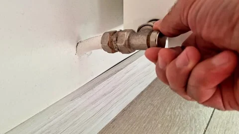 Hand Adjusting Radiator Valve Connection for Home Heating Stock Footage 340948340