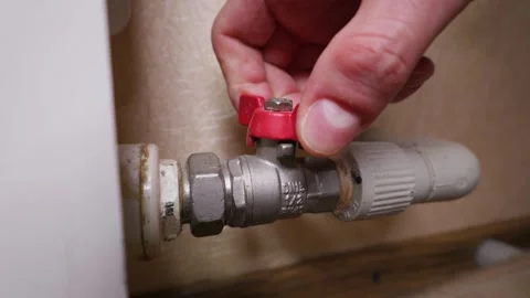 Hand Adjusting Red Butterfly Valve on Water Pipeline System Indoors Stock Footage 339212424