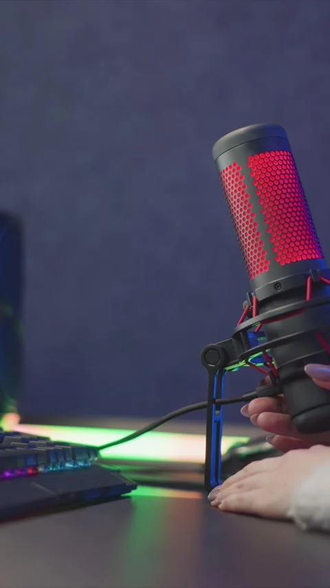 Hand Adjusting Red LED Microphone Near RGB Keyboard With Soft Ambient Lighting Stock Footage 345976343