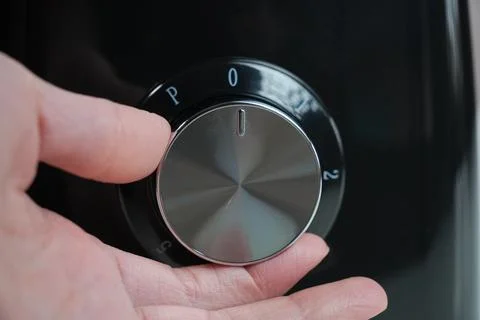 Hand adjusting settings on coffee grinder 스톡 사진