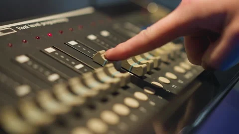 Hand adjusting slider on lighting controller panel for stage lighting Stock Footage 317537505