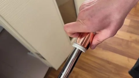 Hand adjusting the telescopic handle of a floor mop. Close up of twisting the Stock Footage 336976565